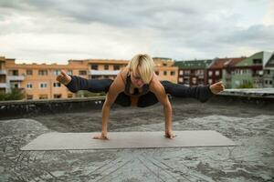 vrouw beoefenen yoga Aan de dak foto