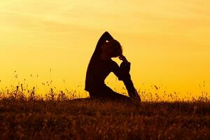 silhouet van vrouw aan het doen yoga foto