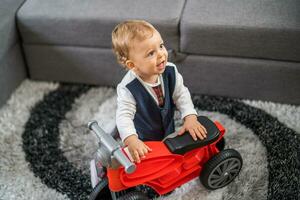 beeld van gelukkig baby jongen met zijn eerste fiets foto