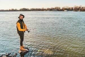 Mens geniet visvangst Bij de rivier- foto