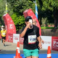 nieuw Delhi, Indië - oktober 15 2023 - vedanta Delhi voor de helft marathon ras na covid in welke marathon deelnemers over naar kruis de af hebben lijn, Delhi voor de helft marathon 2023 foto