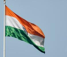 indiase vlag hoog op connaught plaats met trots in blauwe lucht, indiase vlag wapperen, indiase vlag op onafhankelijkheidsdag en republiek dag van india, tilt-up shot, wuivende indische vlag, har ghar tiranga foto