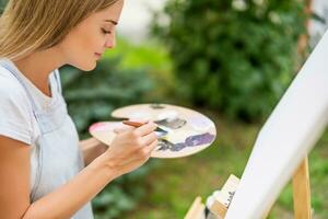 vrouw geniet vrouw schilderij Aan canvas buitenshuis. foto