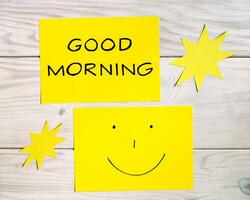 tekst mooi zo ochtend- en smiley gezicht met zon vormen Aan houten tafel foto