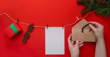 handen zetten een armband gemaakt van natuurlijk stenen in een envelop Aan een Kerstmis samenstelling. foto