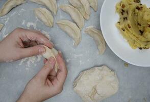 de handen van een kind wie leert naar maken knoedels met aardappelen. selectief focus. foto