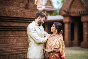Aziatische bruid en blanke bruidegom hebben romantische tijd met thailand jurk foto