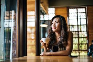 portret aziatische vrouw die lacht ontspannen in coffeeshop cafe foto