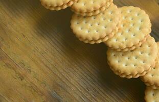 een ronde belegd broodje koekje met kokosnoot vulling leugens in groot hoeveelheden Aan een bruin houten oppervlak. foto van eetbaar behandelt Aan een houten achtergrond met kopiëren ruimte