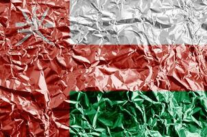 Oman vlag afgebeeld in verf kleuren Aan glimmend verfrommeld aluminium folie detailopname. getextureerde banier Aan ruw achtergrond foto