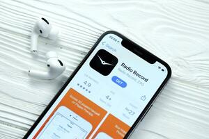 Charkov, Oekraïne - maart 5, 2021 radio Vermelding icoon en toepassing van app op te slaan Aan iphone 12 pro Scherm scherm met airpods pro Aan wit tafel foto