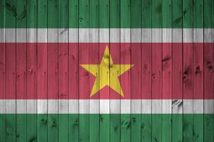 Suriname vlag afgebeeld in helder verf kleuren Aan oud houten muur. getextureerde banier Aan ruw achtergrond foto