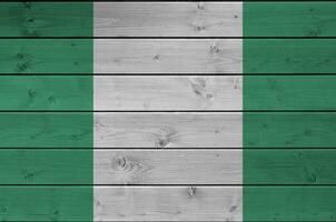 Nigeria vlag afgebeeld in helder verf kleuren Aan oud houten muur. getextureerde banier Aan ruw achtergrond foto