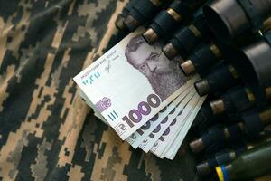 oekraïens leger machine geweer riem schelpen en bundel van hryvnia rekeningen Aan leger uniform. betalingen naar soldaten van de oekraïens leger, salarissen naar de leger foto