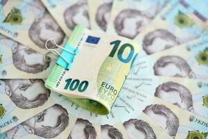 bundel van honderd euro rekeningen leugens Aan veel bankbiljetten van oekraïens hryvnia's. zuinig standaard, crisis en devaluatie van oekraïens nationaal valuta foto