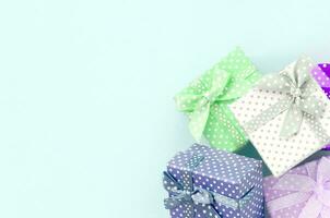 stapel van een klein gekleurde geschenk dozen met linten leugens Aan een paars achtergrond. minimalisme vlak leggen top visie foto