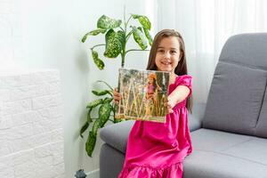 schattig weinig meisje Holding foto canvas Bij huis