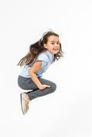 gelukkig schoolmeisje jumping hoog Aan wit achtergrond foto