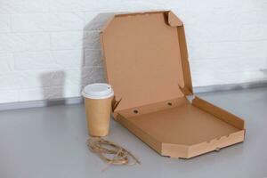 koffie kop en pizza doos Aan wit achtergrond foto