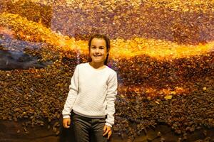 weinig meisje Aan de achtergrond van amber stenen. foto