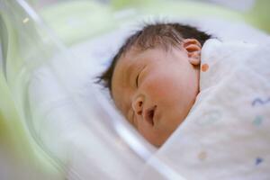 de baby jongen was alleen maar geboren met baby kleding verpakt in de omgeving van de geheel lichaam foto