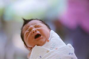 de baby jongen was alleen maar geboren met baby kleding verpakt in de omgeving van de geheel lichaam foto