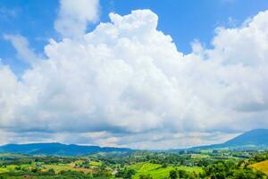 groot wolk vol van lucht Aan de berg en groen veld- helder kleuren in land foto