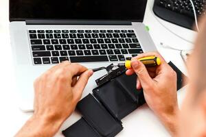 de ingenieur repareert de laptop en het moederbord. installeert de apparatuur foto