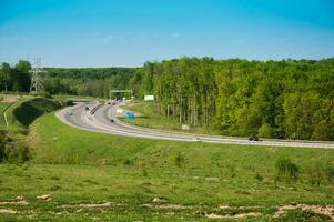 een beurt van een snelweg met groen Woud Bij de Rechtsaf kant foto