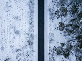 antenne schot van een winter weg in een Woud foto