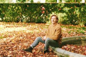 buitenshuis portret van knap volwassen Mens in herfst park foto