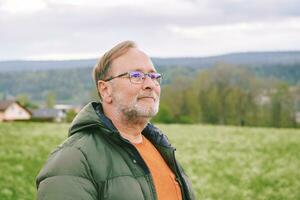 dichtbij omhoog portret van midden- leeftijd Mens genieten van mooi hoor voorjaar dag buiten foto