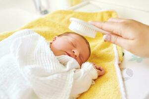 moeder poetsen haar- van slapen pasgeboren baby foto