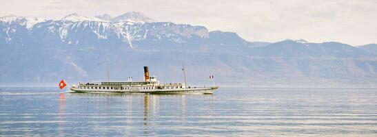 panoramisch banier met stoom- boot met Zwitsers en Frans vlaggen drijvend Aan meer Genève of lak leman, Zwitserland foto