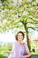 buitenshuis voorjaar portret van gelukkig jong vrouw genieten van mooi hoor zonnig dag foto