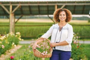 buitenshuis portret van mooi 50 jaar oud vrouw genieten van mooi hoor dag in bloem park of tuin, gelukkig en gezond levensstijl foto