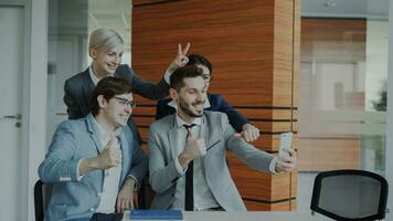 gelukkig bedrijf team nemen selfie portret Aan smartphone camera en poseren voor groep foto gedurende vergadering in modern kantoor binnenshuis