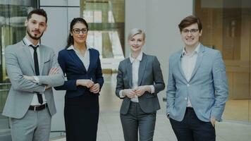 portret van groep van bedrijf mensen glimlachen in modern kantoor binnenshuis. team van zakenlieden en onderneemsters staand samen foto