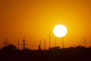 zon achter elektrisch polen in Oekraïne Bij zonsondergang foto