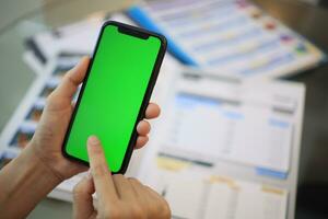 telefoon groen scherm in hand, hand- Holding smartphone groen scherm in huis, gebruik makend van mobiel telefoon groen scherm foto
