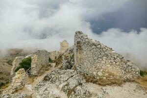 de ruïnes van een oud kasteel in de bergen foto