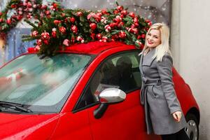 gelukkig jong vrouw met een nieuw auto, Kerstmis Cadeau foto