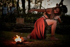 meisje brand dansen prestatie Bij buitenshuis kunst festival, glad bewegingen van vrouw artiest foto