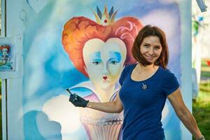 glimlachen vrouw artiest met verf borstel trekt fantasie koningin portret Aan wit canvas foto