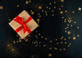 vakantie cadeau gebonden met rood lint op zwarte kerst achtergrond foto