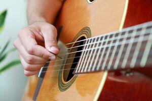 gebruik makend van een plukken voor een akoestisch gitaar. foto