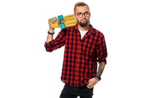 hipster Mens over- wit achtergrond Holding geel skateboard. actief vent in plaid overhemd met kopiëren ruimte foto