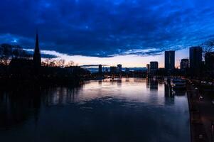 spectaculair visie Aan de nacht stad van Frankfurt reflecterend in de rivier- foto