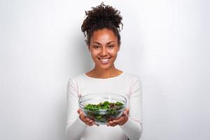 close-upportret van vrouw die zich met kom salade over witachtergrond bevindt foto