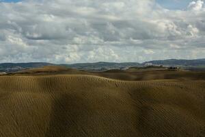 beroemd Toscane landschap met gebogen weg en cipres, Italië, Europa. landelijk boerderij, cipres bomen, groen veld, zonlicht en wolk. foto